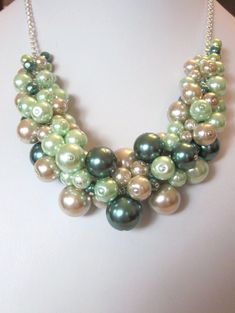 "This lovely Dark Green, Mint and Tan multi-color glass pearl cluster necklace will add the finishing touch to any outfit from casual to elegant.  This is a very gorgeous and fun necklace.   This necklace is adjustable in length from 15\" up to 20\".  Pearls are dark green, mint green and tan in various sizes from 6mm to 25mm.   Each pearl was hand wired to the adjustable length silver plated curb chain.  This is finished with a lobster claw closure.   Shipping to the US is flat rate priority mail small box. For international shipping, Please email for charges and shipping options before you check-out.  Price shown below is for international priority mail flat rate shipping.  Prices vary widely depending on methods. Thank You for looking! SRAJD = Self-Representing Artist in Jewelry Design" Peals Necklace, Pearl Cluster Necklace, Chunky Choker, Gemstone Art, Diy Gemstone, Green Mint, Soft Autumn, Pearl Cluster, Cluster Necklace