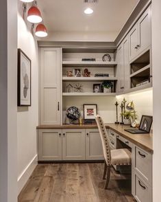 a home office with white cabinets and wood floors