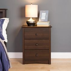 a night stand with two drawers and a lamp