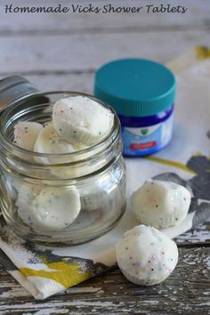 some white marshmallows are in a glass jar on a table next to a napkin