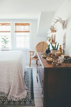 a bedroom with a bed, dresser and window