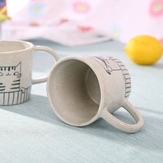 two coffee mugs sitting on top of a table