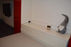 a stuffed animal sitting on top of a white shelf