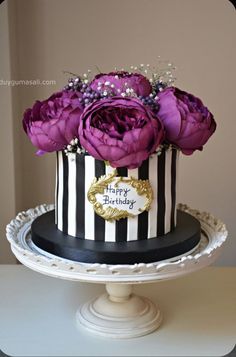 a black and white striped cake with purple flowers on top