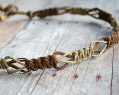 a close up of a rope bracelet on a wooden surface with knots in the middle