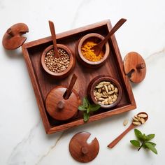 an assortment of spices in wooden bowls and spoons