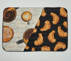 two pieces of fabric with coffee and croissants on them, one is black