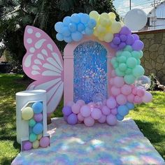 a fairy themed birthday party with balloons and decorations in the shape of a door, butterfly wings