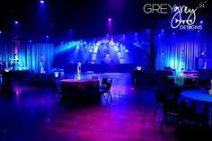 a stage set up for an event with purple and blue lighting