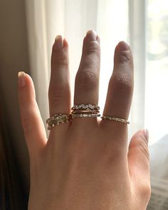 a woman's hand with three different rings on her left and the other half