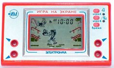 the electronic clock is red and white with blue letters on it's display screen