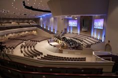 an empty auditorium with rows of seats and lights on the ceiling is seen in this image