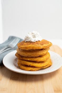 a stack of pancakes with whipped cream on top