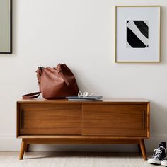 a brown purse sitting on top of a wooden dresser next to a pair of shoes