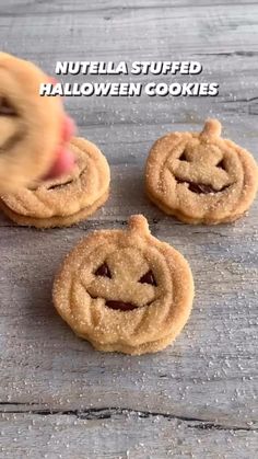 three nutella stuffed halloween cookies sitting on top of a wooden table