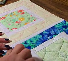 a woman is working on a quilt with scissors