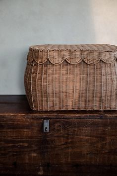 a wicker basket sitting on top of a wooden box