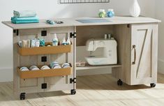 a sewing machine sitting on top of a wooden table next to a shelf filled with items