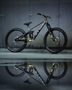 a bike that is sitting on the ground in front of a wall and reflecting it's reflection