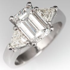 a three stone diamond ring on a white background