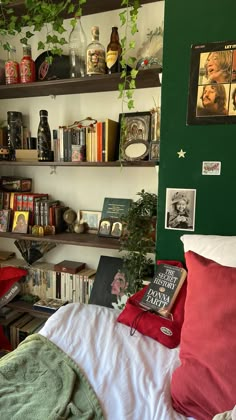 a bed room with a neatly made bed and lots of books on the shelves above it