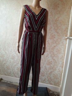 "Striped jumpsuit in red\\white and brown stripes,  a deep V at the front and back and a tie belt.  Very easy to wear, wide palazzo legs' Bust;  40\" Waist;  32\" Inside leg;  27\" Width at ankle;  11\"   Made by OVS         syntheyic" Striped V-neck Jumpsuits And Rompers For Summer, Red Jumpsuits And Rompers For Summer Workwear, Striped Jumpsuits And Rompers For Summer Workwear, Chic Fitted Jumpsuits And Rompers With Vertical Stripes, Red Sleeveless Overalls For Summer, Striped Fitted V-neck Jumpsuit, Red Sleeveless Summer Overalls, Casual Summer Jumpsuits And Rompers With Vertical Stripes, Striped Overalls Jumpsuits For Spring