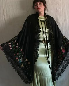 "Beautiful antique Victorian era black satin shawl with silk floral embroidery. Yellow tissue silk lining, two large braided tassel closures at the neckline, and a hook and eye closure below the bust. Black scalloped lace trim. The embroidery on this shawl is unreal and the colors are still extremely vibrant. There are even a few specs of pollen floating around! Measures 90\" x 46\". Condition: Great antique condition. Some fraying/snagging on embroidery, some lightened areas to black satin, and Luxury Black Embroidered Shawl, Elegant Luxury Shawl With Intricate Embroidery, Black Bohemian Shawl For Spring, Black Embroidered Silk Shawl, Black Silk Shawl With Traditional Drape, Black Silk Shawl Traditional Drape, Black Silk Wedding Shawl, Black Shawl With Intricate Embroidery In Traditional Drape, Black Embroidered Shawl With Traditional Drape