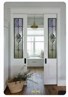 an entryway with stained glass windows and wooden flooring, along with a basket full of plants