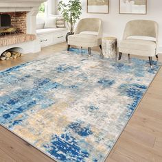 a living room area with two chairs and a rug on the floor in front of a fireplace