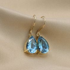 Beautifully matched, these dangling earrings feature two pear shaped London blue topaz gemstone set in 14k gold.Three-prong settings hanging from an elegant French hook. Each stone weighs roughly 2.5 carats, for a total weight of 5.00 carat minimum.- Made to Order, perfectly finished, Fast shipping fully insured and trackable online.- Gemstone information: Two 12x8 mm pear cut, London blue topaz 5.02 ctw- Solid Gold French hook for quick and easy removal.- Arrives gift ready with a certificate o Wedding Gemstone Teardrop Earrings, Wedding Teardrop Gemstone Earrings, Pear-shaped Blue Topaz Jewelry As A Gift, Pear Shaped Blue Topaz Jewelry Gift, Pear Shaped Blue Topaz Jewelry For Gifts, Pear-shaped Blue Topaz Jewelry For Gifts, Elegant Pear-shaped Topaz Jewelry, Blue Topaz Teardrop Birthstone Earrings, Teardrop Blue Topaz Birthstone Earrings