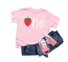 Strawberry One Birthday Shirt Shirt shown on a white or light pink shirt.  Jeans not included.   PLEASE NOTE, I DO NOT HAVE CONTROL OVER THE PACKAGES ONCE THEY LEAVE MY SHOP. ALL SHIPPING IS WITH THE UNITED STATES POSTAL SERVICE FIRST CLASS MAIL UNLESS AN UPGRADE IS PURCHASED, THEN IT IS PRIORITY MAIL. USPS HAS FULL CONTROL OF DELIVERY ONCE IT LEAVES ME! All clothing orders are a three - five business day production time with out the rush order that you can purchase below.  If you have any questions, please feel free to message me.   If you need your order shipping more quickly, please add this link: https://www.etsy.com/listing/454845998/rush-my-order?ref=shop_home_active_1 See my other listings at: https://www.etsy.com/shop/purpleaspenkids?ref=hdr_shop_menu One Year Old Birthday, Light Pink Shirt, Strawberry Birthday, 1st Birthday Shirts, First Birthday Shirts, 1 Birthday, Birthday Tee, One Year Old, 1st Birthday Girls