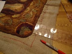 a close up of a piece of cloth on a table with a pen and marker