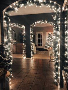 an archway decorated with christmas lights and garlands in a home entry way at night