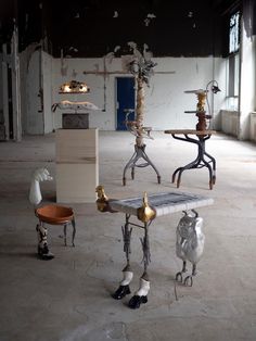 an assortment of sculptures sitting on top of a table in the middle of a room