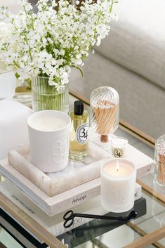 a glass table topped with candles and flowers