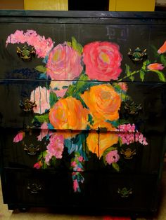 a black dresser with flowers painted on it