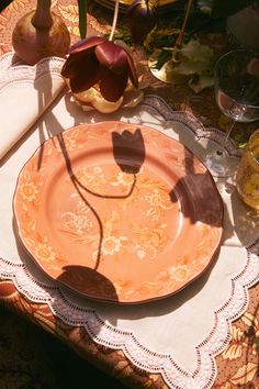 an orange plate sitting on top of a table with utensils next to it