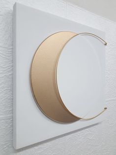 a white wall with a gold circle on it