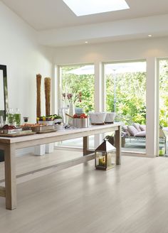 a room with white walls and wood flooring in the center is filled with furniture