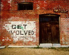 an old red brick building with graffiti on it