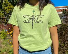 -100% Ultra cotton Gildan T-shirt (color: green) -Comfy cotton T with dragonfly print in black/white fabric ink -machine washable (no heat) -hand carved original print design -models wearing a unisex size small (first model is 5'2 & second model is 5'6) -message for more sizing options -message me with any questions or if you want anything custom Cheap Green Tops With Cartoon Print, Cheap Green Graphic Print Short Sleeve Shirt, Cheap Green Tops With Vintage Print, Cheap Artsy Tops With Graphic Print, Cheap Green Grunge Tops, Cheap Green T-shirt For Layering, Cheap Green Drop Shoulder Tops, Cheap Cotton Screen Print Tops, Cheap Green Tops With Retro Print