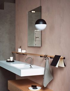 a bathroom with a sink, mirror and lights on the wall next to each other