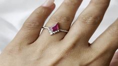 a woman's hand with a diamond and pink tourmaline ring on it