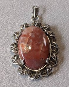 "Sterling Silver Agate Pendant Ornate fine pendant with oval cut Agate prong set in Sterling Silver Pendant is fully hallmarked and will arrive gift boxed. * HALLMARKS 925. * MEASUREMENTS 1 1/4\" x 3/4\" including bale. * WEIGHT 4.08 Grams. * CONDITION Stone has fissures or cracks which are pictured, otherwise pendant looks great. Please use pictures as part of item's description. * MATERIALS Sterling Silver, Agate." Elegant Agate Oval Pendant Jewelry, Oval Cabochon Agate Jewelry For Gifts, Oval Agate Gemstones For Gift, Elegant Oval Agate Jewelry, Silver Agate Oval Cabochon Jewelry, Silver Agate Jewelry Oval Cabochon, Silver Agate Jewelry With Oval Cabochon, Silver Agate Jewelry In Oval Cabochon Shape, Silver Oval Pendant Gemstones For Gifts