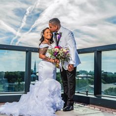 a bride and groom standing on top of a building