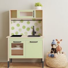 a toy kitchen with green polka dot wallpaper and wooden flooring, including an animal figurine