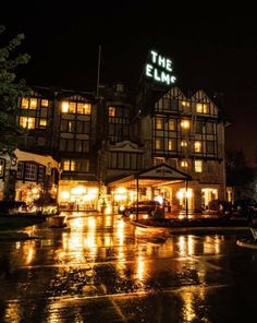 the elm hotel is lit up at night with lights on it's front windows