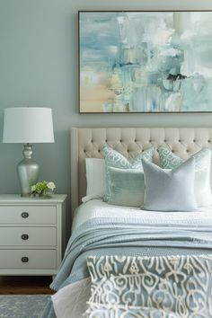 a bedroom with a bed, nightstand and painting on the wall above it's headboard