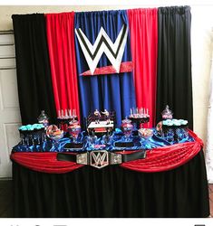 a table topped with cake and cupcakes on top of a black table cloth