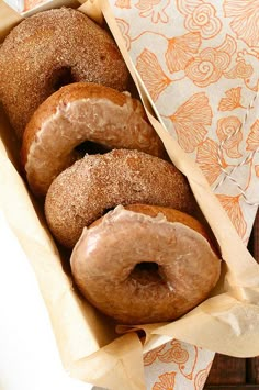 a box filled with donuts on top of a green table next to a napkin